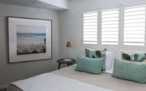een slaapkamer met een bed met kussens en een raam bij Hastings Park Penthouse 6 in Noosa Heads