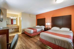 a hotel room with two beds and a desk at Motel 6-Washington, DC - Convention Center in Washington, D.C.