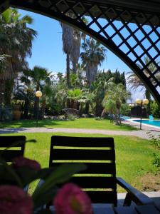 a view of a park with two benches and palm trees at All'Ombra del Palmeto in Taranto