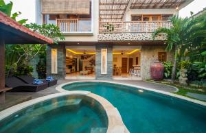 a swimming pool in front of a house at Villa Suzuki 2 Seminyak in Seminyak