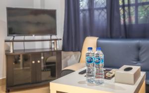 two water bottles on a coffee table in front of a tv at Baan Suan Villa 1 in Patong Beach