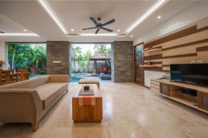 un soggiorno con divano e TV a schermo piatto di Villa Suzuki 2 Seminyak a Seminyak
