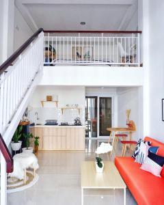 ein Wohnzimmer mit einem roten Sofa und einer Treppe in der Unterkunft The Sloth Bali in Canggu