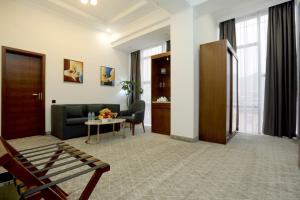a living room with a couch and a table at Parliament Palace Hotel in Khujand