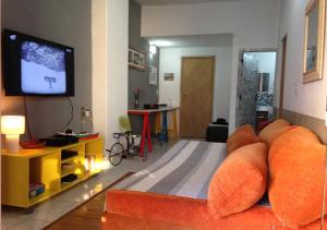 sala de estar con sofá y TV de pantalla plana en Confortável Cobertura Copacabana, en Río de Janeiro
