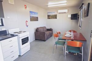 a kitchen and dining room with a table and a couch at Lake Callide Retreat in Biloela
