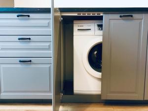 a laundry room with a washer and dryer in it at Taikos apartamentai Nidoje in Nida