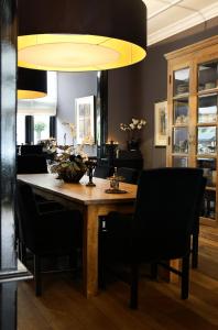 a dining room with a wooden table and black chairs at Residenz Stadslogement in The Hague