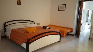 a bedroom with a bed with an orange blanket at Casa Unci in Canneto