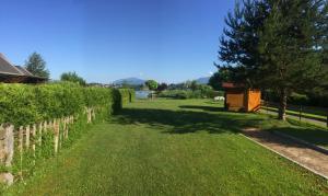 a grassy yard with a fence and a tree at Ferienhaus Rafaela mit Privatstrand in Ledenitzen