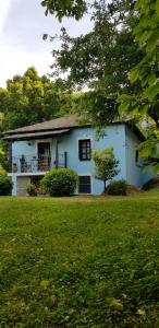 a blue house with a balcony in a yard at Tsagarada Stone House 1898 in Tsagarada