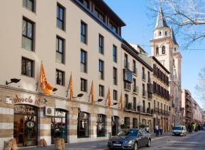 un'auto parcheggiata di fronte a un edificio con una torre dell'orologio di Vincci Albayzin a Granada