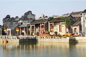 un grupo de casas junto a un cuerpo de agua en University Town International Hotel en Guangzhou