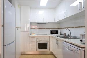 een witte keuken met witte kasten en een magnetron bij Cosy Friendly Centre Alicante in Alicante