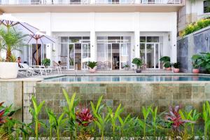 una piscina frente a una casa con plantas en The Sloth Bali, en Canggu