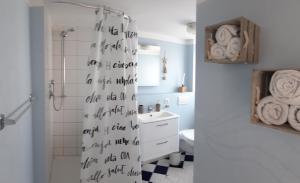 a bathroom with a shower curtain with writing on it at Arthouse Apartment in Bad Vilbel