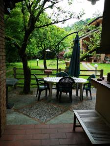 a patio with a table and an umbrella and chairs at I Tre Abeti - Holiday House in Vezzano Ligure