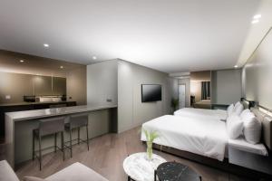 a hotel room with a bed and a kitchen at SR Suites Bundang in Seongnam