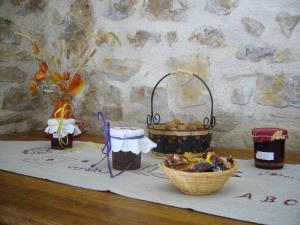 einen Tisch mit einem Korb mit Lebensmitteln und einem Obstkorb in der Unterkunft LA GRANGE DU RIAL in Bournazel