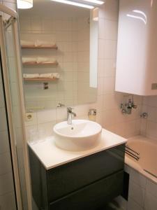 een badkamer met een witte wastafel en een bad bij Mountain View City Center in Innsbruck