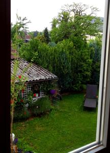 a window view of a yard with a small house at Arthouse Apartment in Bad Vilbel