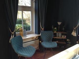 two chairs sitting in a room with a window at De Grote Belt in Oene
