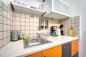 cocina con fregadero y pared de azulejos en Athens metro apartment, en Atenas 17 fotos más
