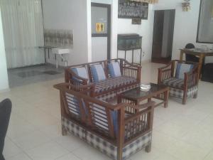 3 Stühle und ein Tisch in einem Zimmer in der Unterkunft Larn's Villa Hotel & Apartment in Wadduwa