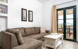 a living room with a couch and a table at Iliada Villas in Agios Prokopios