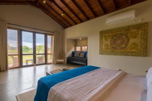 a bedroom with a large bed and a large window at Kumbukgaha Villa in Sigiriya