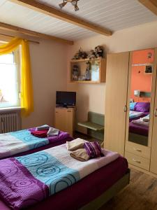 a bedroom with two beds and a mirror at Pension Stürrad in Neuharlingersiel