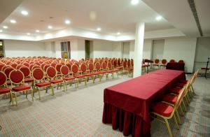 a conference room with red chairs and a table at Skyna Hotel Luanda in Luanda