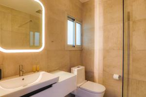 Un baño con lavabo, inodoro y espejo. en Vega Apartments, en Limassol 32 fotos más