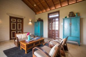 sala de estar con sofá, mesa y sillas en Kumbukgaha Villa, en Sigiriya