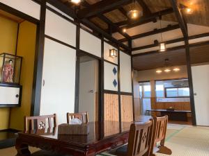 comedor con mesa de madera y sillas en Condominium WAFU TEI Okinawa city, en Okinawa City