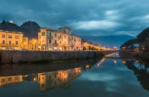 a city with buildings and a river at night at Olimpus in Sora