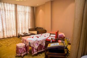 a room with a bed and a chair and a couch at Rongjiang Hotel in Jieyang