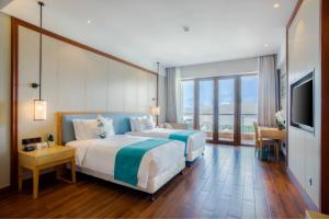Кровать или кровати в номере Sanya Dadonghai Seaview Hotel