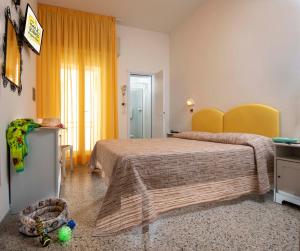 una camera con un grande letto e una tenda gialla di Hotel St. Moritz a Rimini