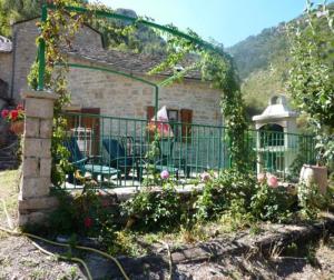 een huis met een hek en bloemen in de tuin bij Gite la maison de Jules in Sainte-Énimie