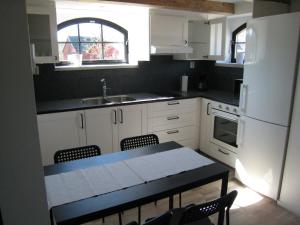 uma cozinha com armários brancos e uma mesa com cadeiras em stixered fegen em Fegen
