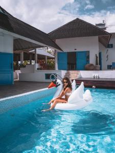 Una donna è seduta su una zattera di unicorno in una piscina di Bali Bio Villas a Uluwatu