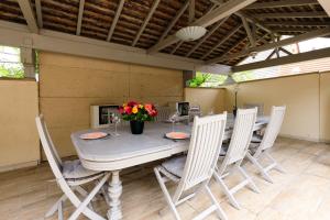 a dining room table with chairs and flowers on it at Les Chambres de Clem' in Bernardswiller