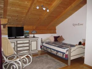 een slaapkamer met een bed en een bureau met een televisie bij Ferienwohnung Bei Mutti in Rottau