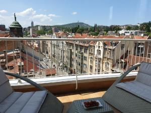 uma varanda com 2 cadeiras e vista para a cidade em Apartment Royal Residence em Sarajevo