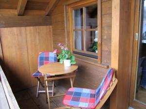 a small table and chairs on the porch of a tiny house at Ferienwohnung Bei Mutti in Rottau