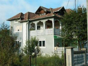 a large white house with a balcony on top of it at Pensiunea Tarina in Şuncuiuş
