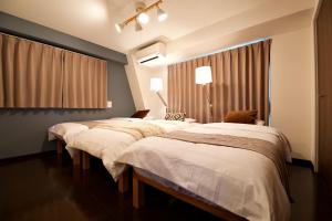 東京にあるKanbe Building 301の部屋に3つのベッドがあるグループ