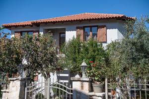 uma casa com cerca e árvores em Andromia Studios & Apartments em Agia Marina Nea Kydonias