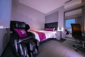 a purple room with a bed and a chair at Miyakonojo Green Hotel in Miyakonozyō +58 photos